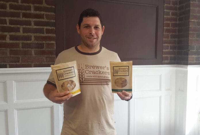 Brewer's Crackers co-owner holding 2 bags of crackers